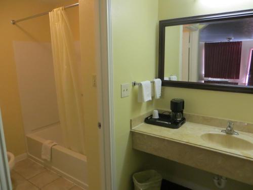 a bathroom with a sink and a shower at Americas Best Value Inn & Suites Hempstead in Hempstead