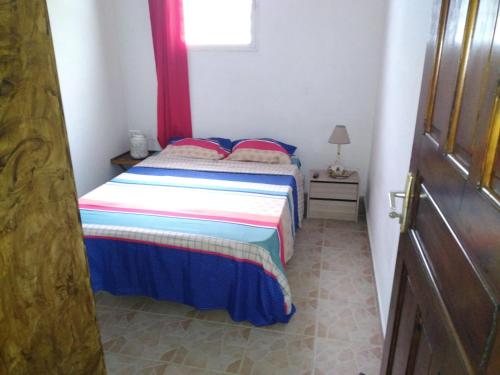 a small bedroom with a bed and a window at Maison chaleureuse avec vue sur mer in Terre-de-Haut