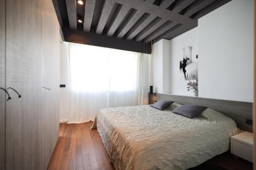 een slaapkamer met een bed en een groot raam bij Apartment F in Zadar