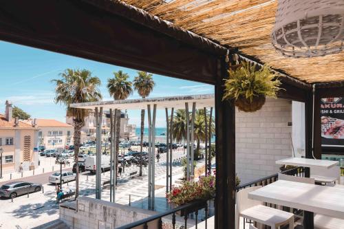 卡斯凱什的住宿－卡斯卡伊斯灣旅館，从餐厅的阳台上可欣赏到海滩景色