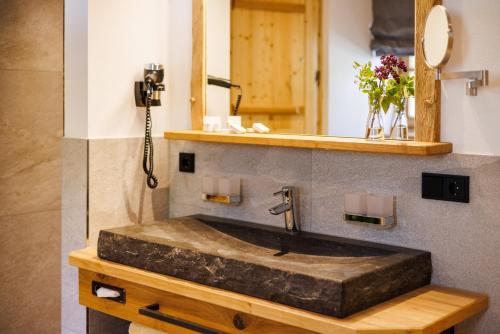 a bathroom with a stone sink and a mirror at Steinberger Hof Alm inkl. Chiemgau Karte in Ruhpolding