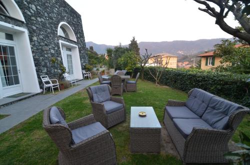 a patio with chairs and couches and a table at Villa Margherita in Levanto