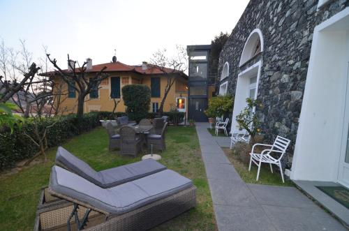 a patio with chairs and tables in a yard at Villa Margherita in Levanto
