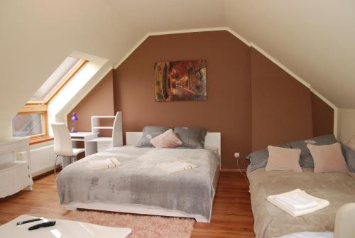 ein Schlafzimmer mit einem Bett und einem Schreibtisch im Dachgeschoss in der Unterkunft Apartament Vistula in Wisła
