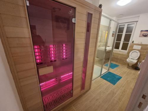 y baño con ducha con luces rosas. en Privée : Jacuzzi + sauna + billard + jeux SO en Saint-Quentin