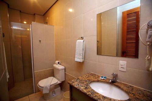 bagno con lavandino, servizi igienici e specchio di Cinelandia Hotel a San Paolo