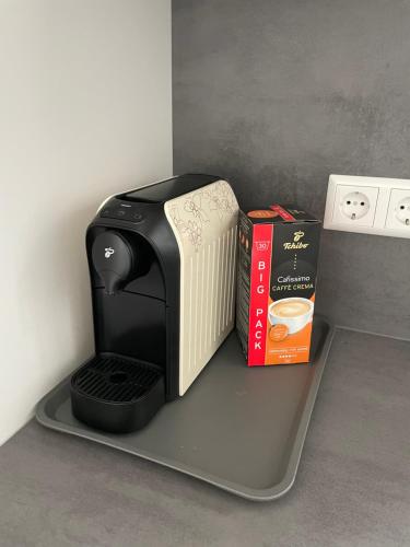 a coffee maker on a shelf next to two books at Ferienwohnung Basner in Lahr