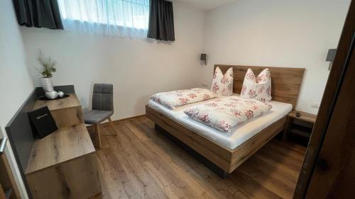 a bedroom with a bed with pillows and a chair at Alpenresidenz M Vermietungs KG in See