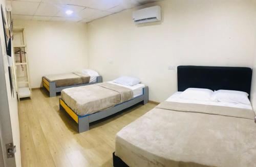 um quarto com duas camas num quarto em Pak Long Shoplot Homestay 2 em Shah Alam