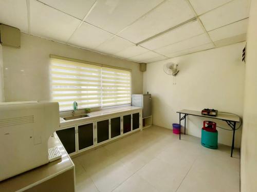 uma cozinha com um lavatório e uma mesa num quarto em Pak Long Shoplot Homestay 2 em Shah Alam