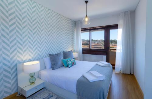 a bedroom with a white bed and a window at 180º Porto River View in Vila Nova de Gaia