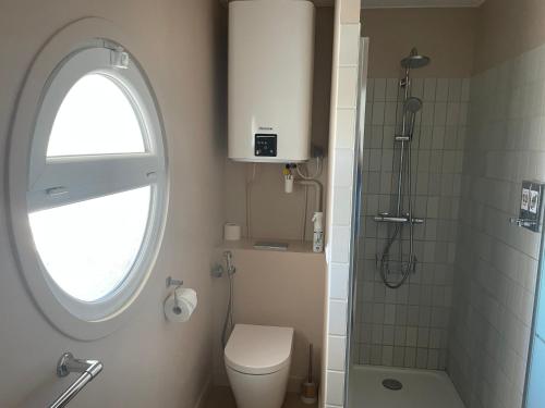 a bathroom with a toilet and a window and a shower at Vue sur rade appartement élégant vaste climatisé étage élevé ascenseur proche parking et toutes commodités au cœur du Toulon historique in Toulon