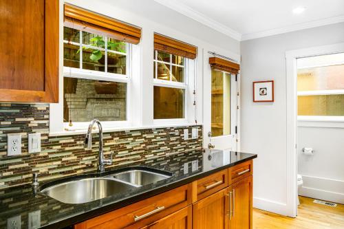 a kitchen with a sink and two windows at Queen Anne Charmer in Seattle