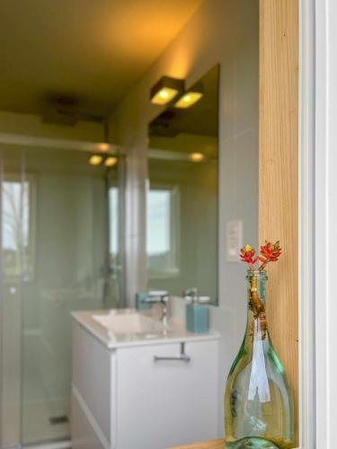 a bathroom with a glass bottle with flowers in it at La Quintana De José in Muros de Nalón