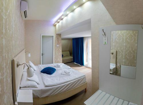 a small room with a bed with a mirror at Bástya Konferencia és Wellness Hotel in Miskolctapolca