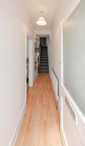 an empty hallway with a staircase in a house at Cheerful 4 bedrooms home 8 mn to train station in Plumstead