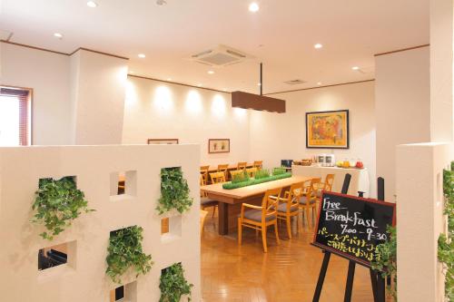 a dining room with a table and chairs and a sign at Odakyu Station Hotel Hon-Atsugi in Atsugi