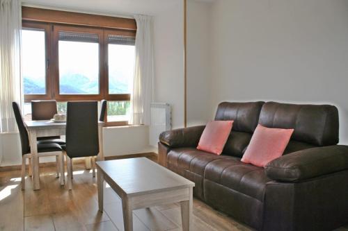Una sala de estar con un sofá de cuero y una mesa. en Los Casares, en Riaño