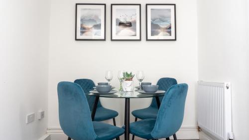 Un comedor con una mesa y sillas azules. en Heyes House - Air Host & Stay - Free parking - Contractor Friendly, en Liverpool