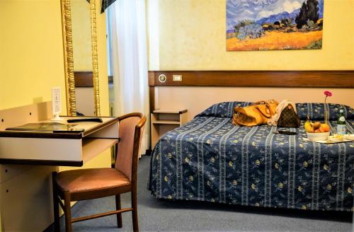 a hotel room with a bed with a table and a desk at Bes Hotel Papa San Pellegrino Terme in San Pellegrino Terme
