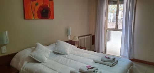 a bedroom with a white bed with towels on it at Hotel AATRAC Buenos Aires in Buenos Aires