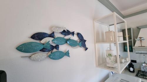 eine Wand mit Fischdekorationen an einer Wand in der Unterkunft Villetta Danila Pugnochiuso Le Macine in Vieste