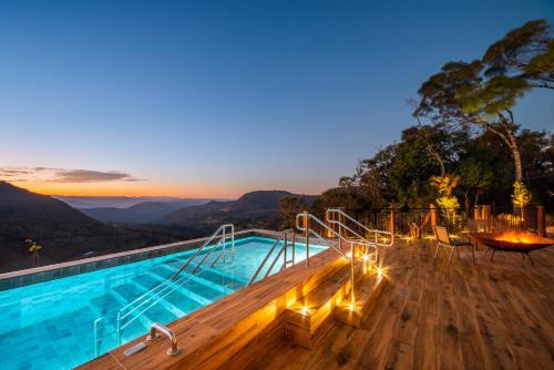 uma piscina com vista para as montanhas à noite em Chateau Laghetto Collection em Gramado