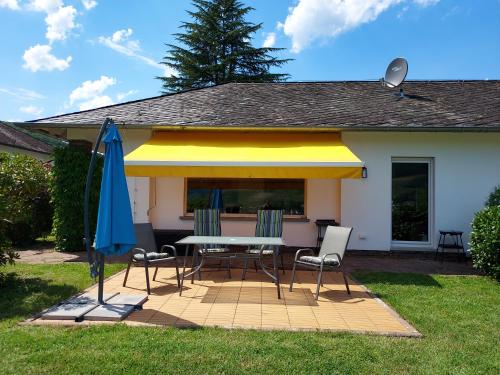 a patio with a table and chairs and an umbrella at Ferienhaus Zum Prinzenkopf in Alf