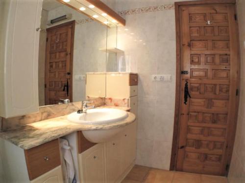 La salle de bains est pourvue d'un lavabo, d'un miroir et d'une porte. dans l'établissement Casa Yaima, à Dénia