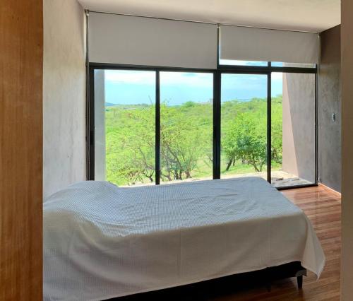 a bedroom with a bed and a large window at Casa de campo in Villa San Nicolás
