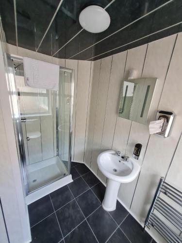 a bathroom with a sink and a shower at Queens Plaza Hotel in Blackpool