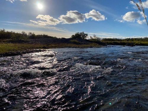 a river with the sun reflecting on the water at Álftártunga Farm Guesthouse in Borgarnes