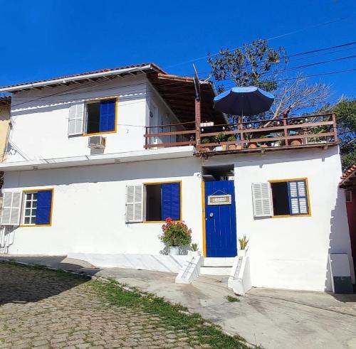 una casa blanca con una puerta azul en Casa Colomba, en Búzios