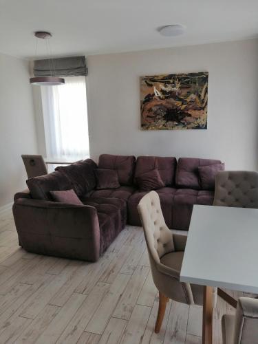 a living room with a brown couch and a table at Savaitė Vilniuje in Vilnius