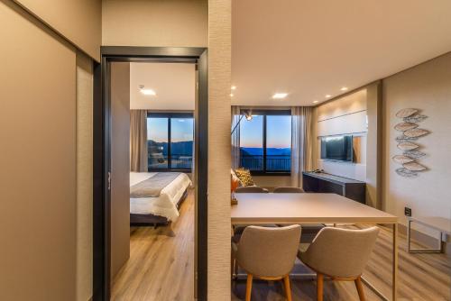 a room with a bed and a table and chairs at Chateau Laghetto Collection in Gramado