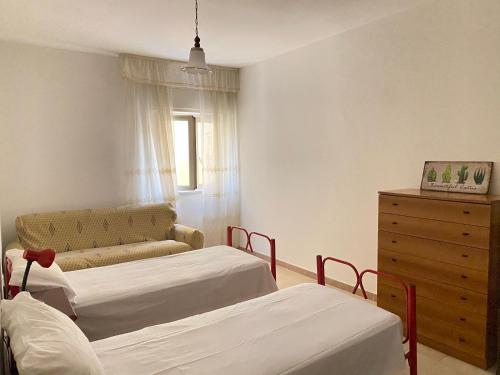 - une chambre avec deux lits, une commode et un canapé dans l'établissement Casa vacanze CoMì, à Santa Maria del Cedro
