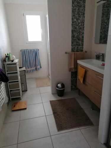 La salle de bains est pourvue de carrelage blanc et d'un lavabo. dans l'établissement Villa Lembarrat vue sur côteaux jardin et piscine privée couverte, accès PMR facilité, à Calignac