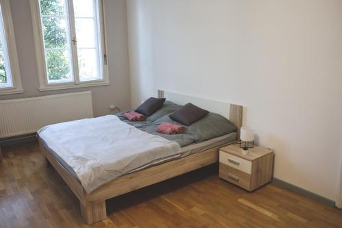 a bedroom with a bed with two pink pillows on it at Vácz Up! Apartment & Studio in Vác
