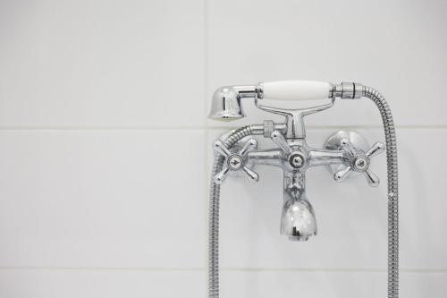 d'un pommeau de douche dans la salle de bains pourvue d'un tuyau dans l'établissement Vácz Up! Apartment & Studio, à Vác