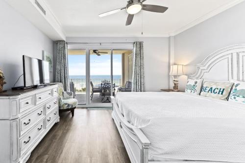 a white bedroom with a large bed and a view of the ocean at Regency Isle Unit 307 in Orange Beach