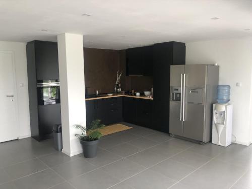 a kitchen with black cabinets and a stainless steel refrigerator at Relax House Banja Luka in Banja Luka