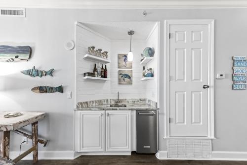 a kitchen with a sink and a white door at Regency Isle Unit 307 in Orange Beach