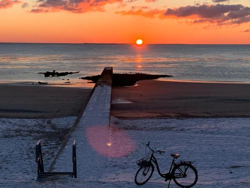 a bike parked on the beach at sunset at Lüttje Najade in Borkum