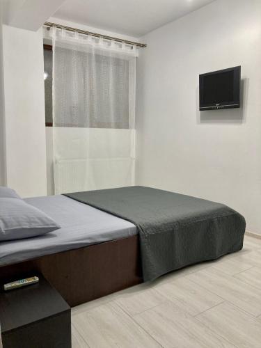 a bedroom with a bed and a flat screen tv at Apartament Luca in Drobeta-Turnu Severin