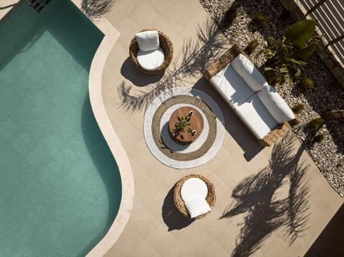 an overhead view of a swimming pool with chairs and a table at Conte Nobile Villa, a Rejuvenating Retreat, By ThinkVilla in Vasilikos
