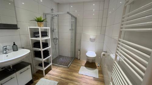 W łazience znajduje się prysznic, toaleta i umywalka. w obiekcie Fischers Nordseehaus Bungalow mit Garten w mieście Wilhelmshaven