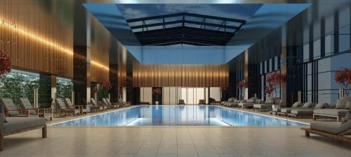 a large swimming pool in a building with chairs at Luxury Studio @ Axis Towers in Heart of Tbilisi in Tbilisi City