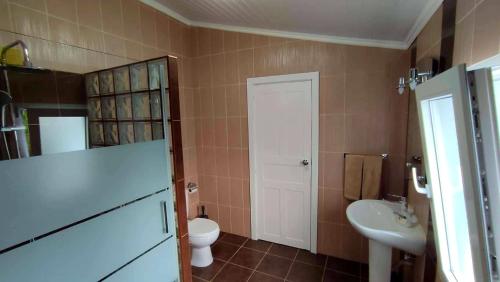 a bathroom with a toilet and a sink at Apartamento do Marquês in Santa Cruz das Flores