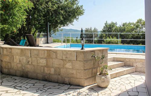 a stone retaining wall next to a swimming pool at Beautiful Home In Lovorno With 4 Bedrooms, Wifi And Outdoor Swimming Pool in Lovorno