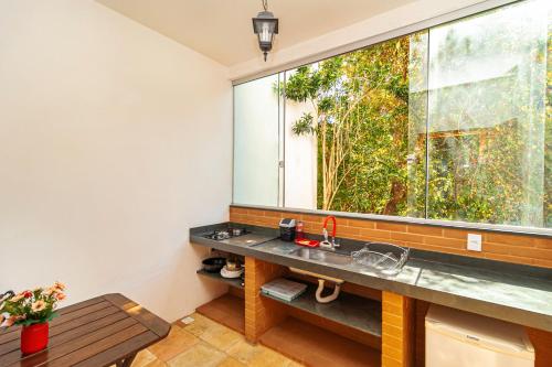 a bathroom with a sink and a large window at Pousada Arvoredo in Pirenópolis
